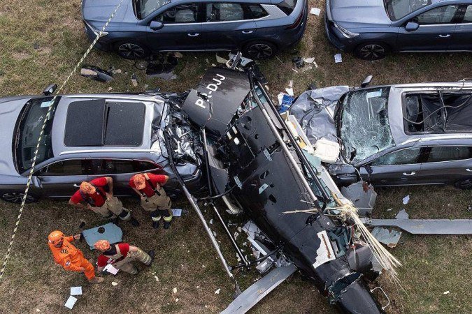 Policias analisam área de acidente em que helicópteros caíram sobre carros
