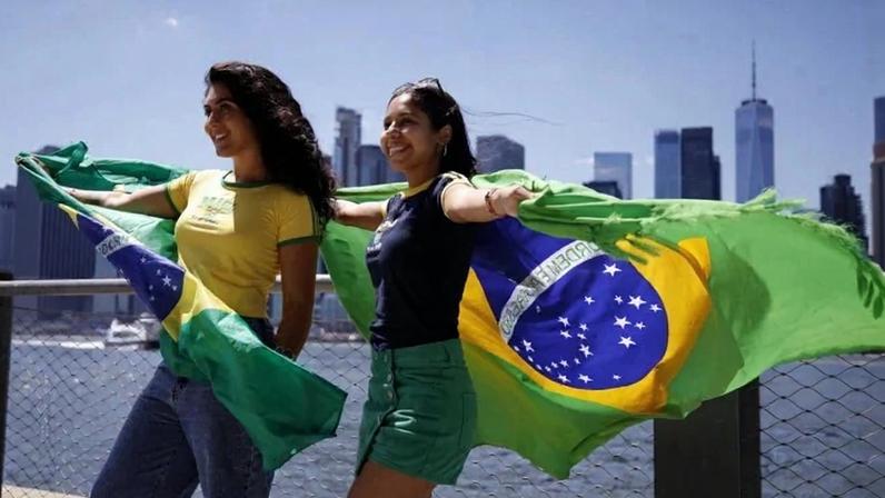 Torcedoras com a camisa e bandeira do Brasil na fan zone do Brooklyn, em Nova York: símbolos nacionais em disputa - (crédito: Leonardo Munoz/AFP)