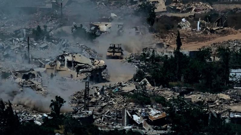 Tanques Merkava, das Forças de Defesa de Israel, deslocam-se por estrada no sul do Líbano, em meio a prédios destruídos - (crédito: Jack Guez/AFP)