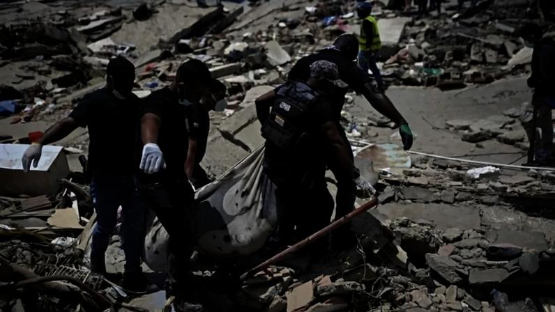 Membros da Polícia Nacional Bolivariana carregam corpos de vítimas dos tremores, em Caraballeda, no estado de La Guaira - (crédito: Federico Parra/AFP)