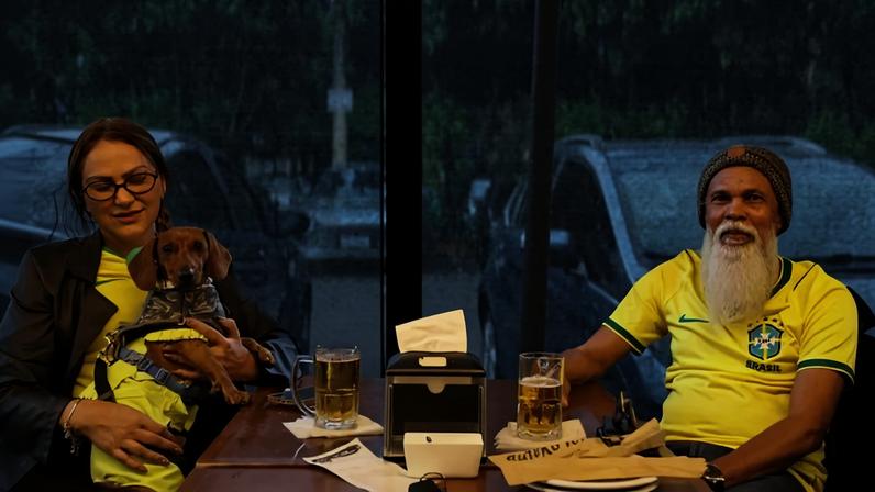 Meirian de Souza, biomédica de 47 anos, e Ismael Paz, 68, engenheiro, assistiam à abertura da Copa do Mundo no Buteko 100, no Sudoeste, com seu cachorro salsicha Simba - (crédito: Davi Pereira/CB/D.A Press)