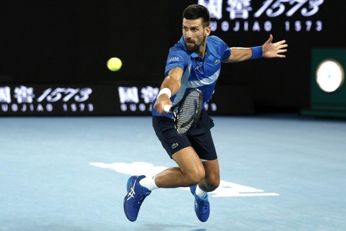 Serbia's Novak Djokovic hits a return against Spain's Carlos Alcaraz during their men's singles quarterfinal match on day ten of the Australian Open tennis tournament in Melbourne on January 22, 2025. (Photo by Martin KEEP / AFP) / -- IMAGE RESTRICTED TO EDITORIAL USE - STRICTLY NO COMMERCIAL USE --