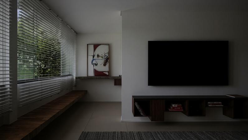 Bancos engastados favorecem um visual minimalista e otimizam espaços. Nesta sala, o banco usa tacos de madeira antigos do apartamento. Arte assinada por Marcelo Solá, na Galeria Index — Foto: Júlia Tótoli/Divulgação | Projeto do arquiteto Bruno Pessoa, do Studio Ark