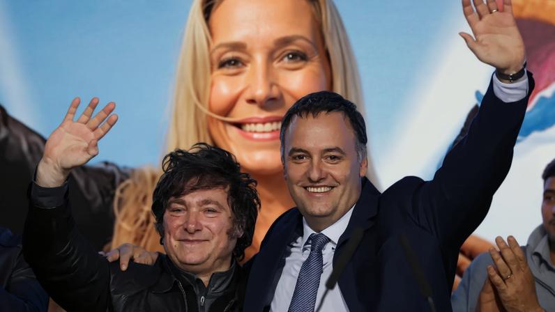 O presidente da Argentina, Javier Milei, e o porta-voz presidencial e candidato legislativo na cidade de Buenos Aires, Manuel Adorni, acenam e se abraçam no palco da sede do partido La Libertad Avanza no dia das eleições legislativas da cidade de Buenos Aires, Argentina, 18 de maio de 2025. REUTERS/Tomas Cuesta