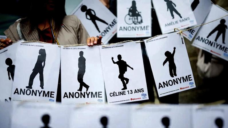 Uma pessoa segura cartazes enquanto um grupo de supostas vítimas, membros de coletivos femininos, ONGs e sindicatos se reúne em frente ao tribunal no dia do veredicto do ex-cirurgião Joel Le Scouarnec, acusado de estupro agravado e abuso sexual contra centenas de crianças ao longo de várias décadas, no tribunal de Vannes, Bretanha, França, 28 de maio de 2025. REUTERS/Stephane Mahe TPX IMAGENS DO DIA