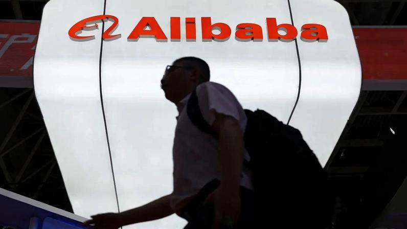 Um homem passa pelo logotipo do Alibaba exibido em seu estande durante a China International Supply Chain Expo em Pequim, China, em 16 de julho de 2025. REUTERS/Florence Lo