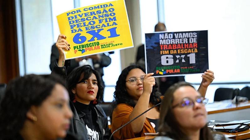 Convidados exibem cartazes na audiência pública.