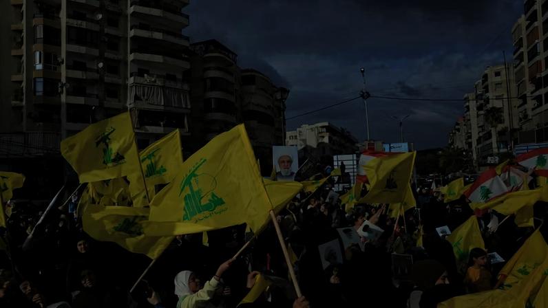 Pessoas seguram bandeiras do Hezbollah durante uma homenagem à retirada de Israel do sul do Líbano em 2000, nos subúrbios do sul de Beirute, Líbano, em 25 de maio de 2026