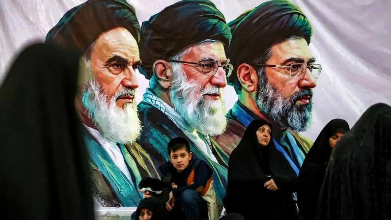 Pessoas se reúnem perto de uma faixa com imagens do falecido líder da Revolução Islâmica do Irã, aiatolá Ruhollah Khomeini, do falecido líder supremo do Irã, aiatolá Ali Khamenei, e do líder supremo do Irã, Mojtaba Khamenei, no dia de uma cerimônia pelo 37º aniversário da morte de Ruhollah Khomeini, no mausoléu de Khomeini, no sul de Teerã, Irã, em 4 de junho de 2026. Majid Asgaripour/WANA (West Asia News Agency) via REUTERS.