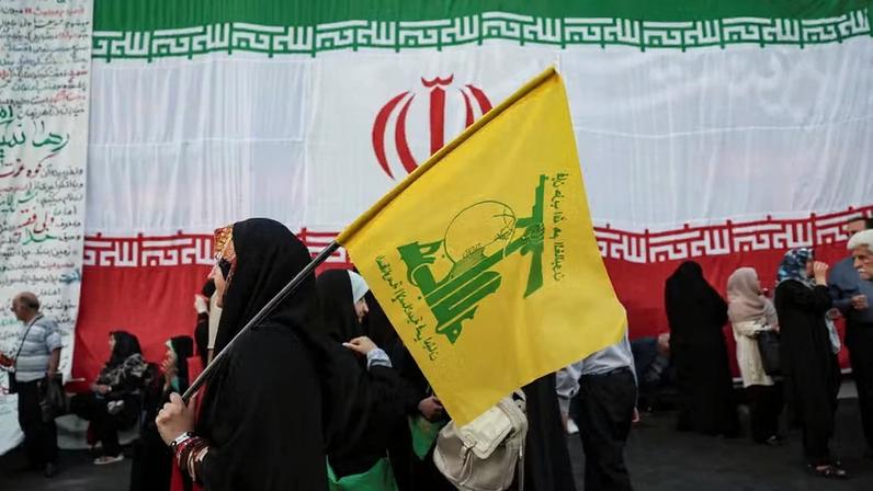 Uma mulher segura uma bandeira do Hezbollah durante um comício em apoio ao Líder Supremo do Irã , Mujahidin Khamenei, em Teerã, Irã , 4 de junho de 2026 — Foto: Majid Asgaripour/WANA (West Asia News Agency) via REUTERS