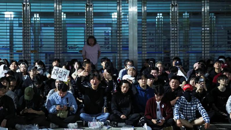 Manifestantes sentam do lado de fora de um local de contagem de votos em Seul em protesto pela falta de cédulas de votação nas eleições locais na Coreia do Sul. Foto: REUTERS/Kim Hong-Ji
