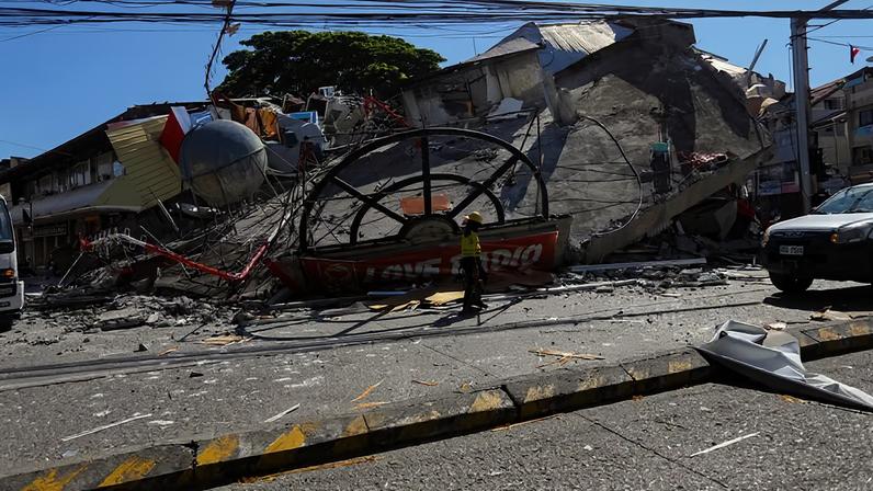 Um trabalhador caminha perto de um prédio que desabou após o terremoto de magnitude 7,8 em General Santos, no sul das Filipinas, em 8 de junho de 2026
