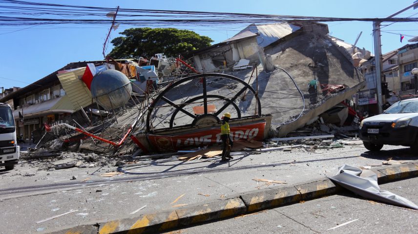 Um trabalhador caminha perto de um prédio que desabou após o terremoto de magnitude 7,8 em General Santos, no sul das Filipinas — Foto: Reuters