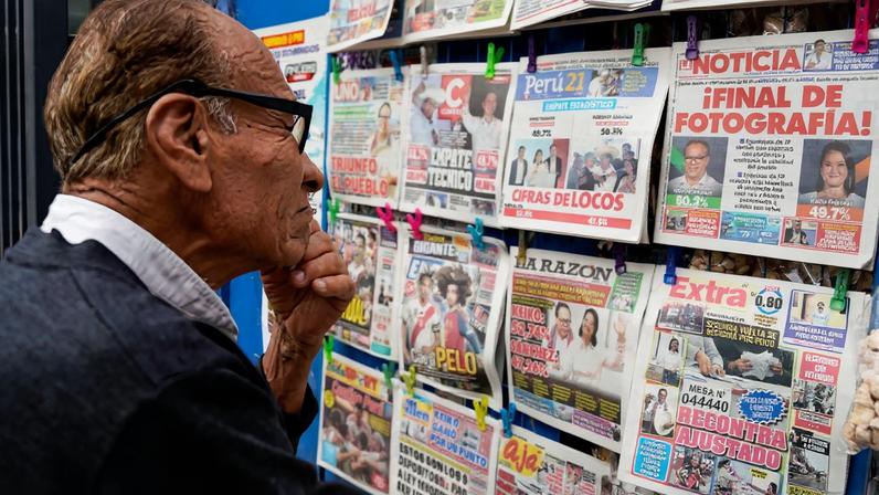 A man looks at a newspaper stand with headlines showing early results of a runoff election between conservative presidential candidate Keiko Fujimori and left-wing candidate Roberto Sanchez, as Fujimori kept a slight lead over Sanchez, with over 90% of the votes counted, according to an official tally, in Lima, Peru, June 8, 2026. REUTERS/Leslie Moreno