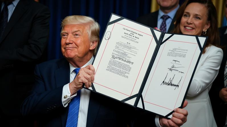 O presidente dos EUA, Donald Trump, exibe o Ato de Segurança da América após assiná-lo no Salão Oval da Casa Branca — Foto: REUTERS/Evan Vucci