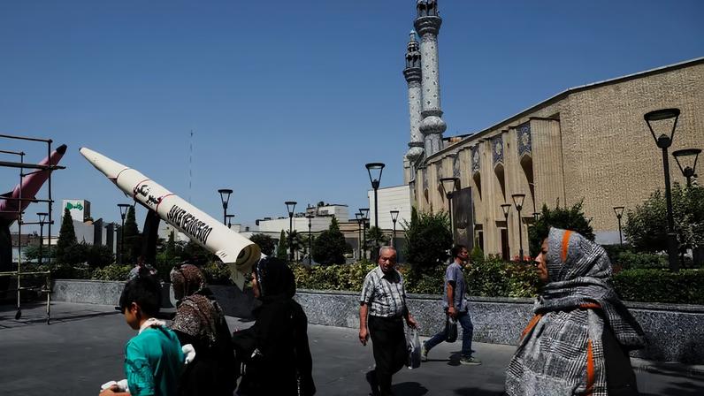 Iranianos caminham perto de escultura que representa míssil do Irã em rua de Teerã no dia 11 de junho de 2026 — Foto: Majid Asgaripour/Wana/Reuters