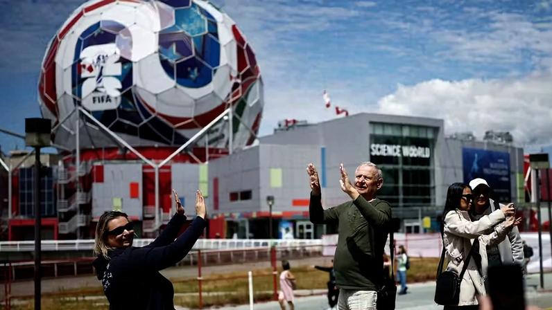 Futebol - Copa do Mundo FIFA 2026 - Vancouver, Canadá - 11 de junho de 2026. Torcedores são fotografados perto de uma bola de futebol gigante em Vancouver, antes da Copa do Mundo FIFA