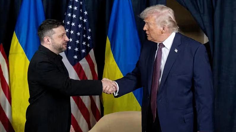 O presidente ucraniano Volodymyr Zelensky e o presidente dos EUA Donald Trump apertam as mãos durante reunião à margem do 56º Fórum Econômico Mundial (FEM), em Davos, Suíça, em 22 de janeiro de 2026