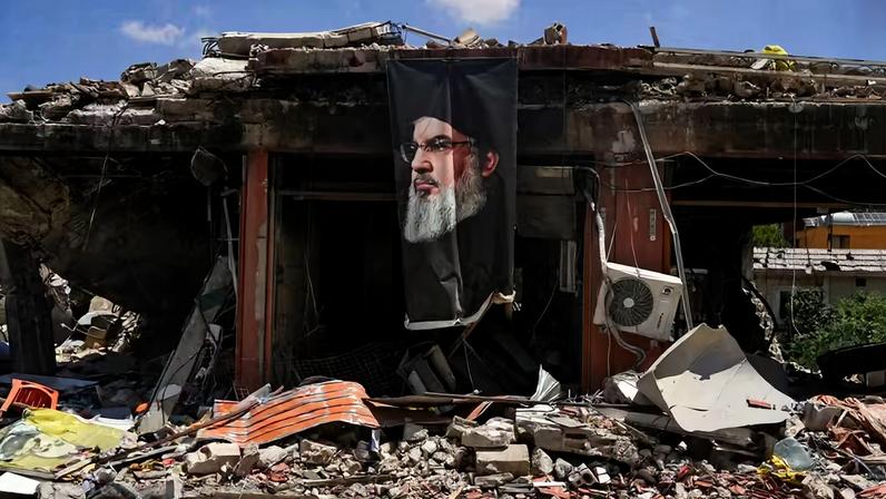 Uma faixa com a imagem do falecido líder do Hezbollah, Hassan Nasrallah, está pendurada em um prédio destruído em Jibchit, distrito de Nabatieh, Líbano, em 16 de junho de 2026, após um acordo entre os Estados Unidos e o Irã