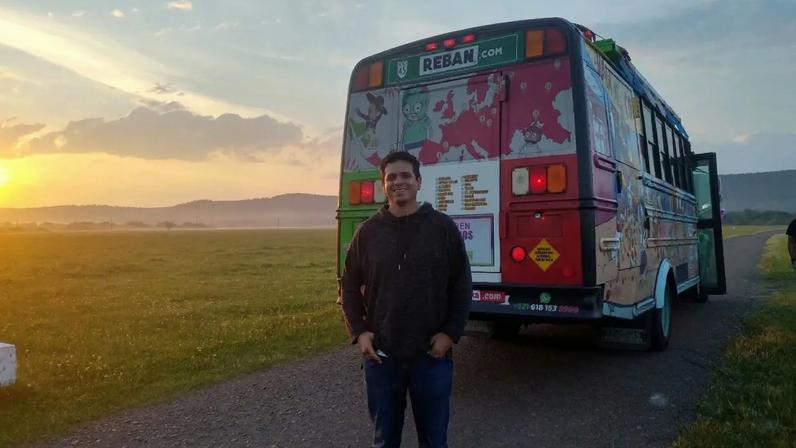Eduardo Marin posa para uma foto ao lado de ônibus pintado por ele e seus amigos, com partes nas cores da bandeira do México com o qual atravessaram a Europa para acompanhar a seleção mexicana durante a Copa do Mundo de 2018 na Rússia, em Rostov, Rússia, 25 de junho de 2018. Eduardo Marin/Divulgação via REUTERS