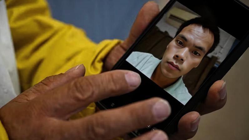 Yanfeng Ge mostra uma foto de seu irmão, Chaofeng Ge , que foi encontrado morto sob custódia do ICE em 2025, em Dickens, Texas, EUA, em 26 de maio de 2026