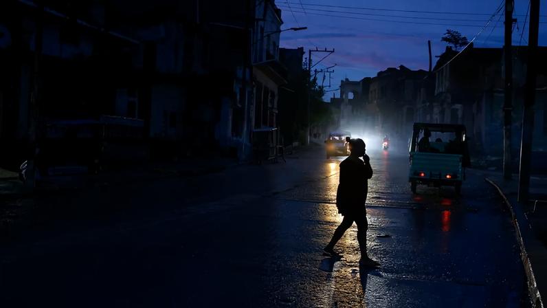 Mulher atravessa a rua no escuro, enquanto Havana sofre com apagões de 20 horas em Havana, Cuba 10 de junho de 2026 REUTERS/Norlys Perez