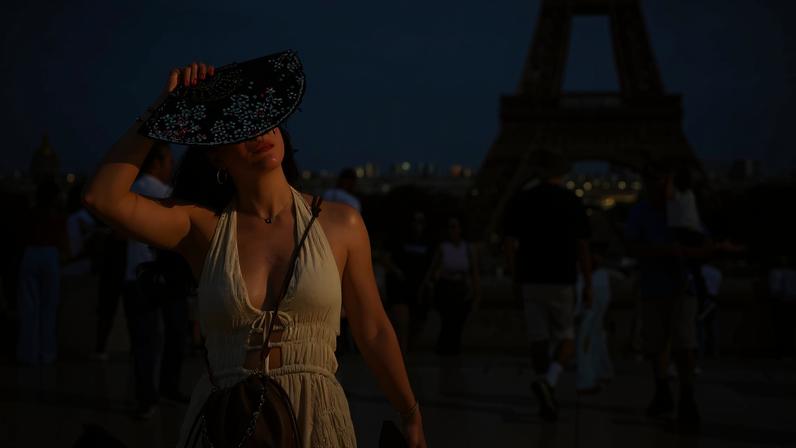 Uma mulher com um leque está na Praça do Trocadero, perto da Torre Eiffel, enquanto as temperaturas sobem em Paris durante a segunda onda de calor que afeta grande parte da França, em 20 de junho de 2026. REUTERS/Sarah Meyssonnier