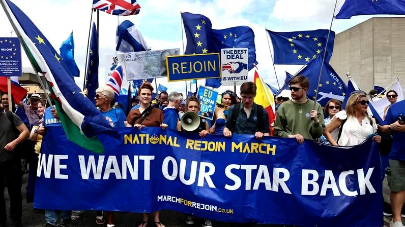 Pessoas seguram uma faixa durante a Marcha Nacional pela Reintegração IV, organizada pela Marcha Nacional pela Reintegração (NRM), que marca os dez anos da votação do Reino Unido para deixar a União Europeia em 2016 e pede uma cooperação mais estreita entre o Reino Unido e a Europa, em Londres, Reino Unido, 20 de junho de 2026