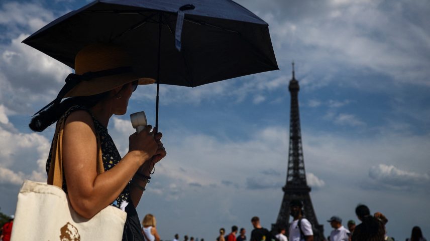 Uma mulher se protege do sol com um guarda-chuva na Praça do Trocadero, perto da Torre Eiffel, enquanto as temperaturas sobem em Paris durante a segunda onda de calor que afeta grande parte da França, em 20 de junho de 2026 — Foto: REUTERS/Sarah Meyssonnier