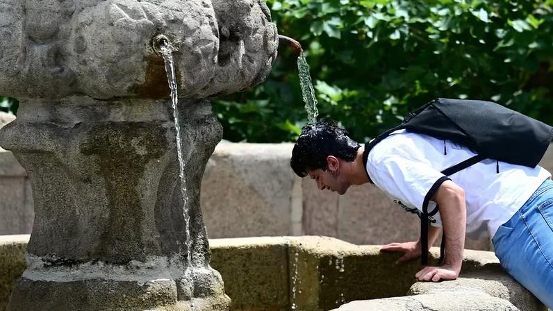 Um homem se refresca em uma fonte, enquanto os moradores de Madri enfrentam altas temperaturas , em Madri, Espanha, 20 de junho de 2026