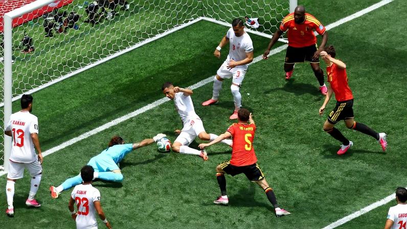 Iran's Alireza Beiranvand in action with Belgium's Maxim De Cuyper, Iran's Ali Nemati and Belgium's Hans Vanaken as he makes a save