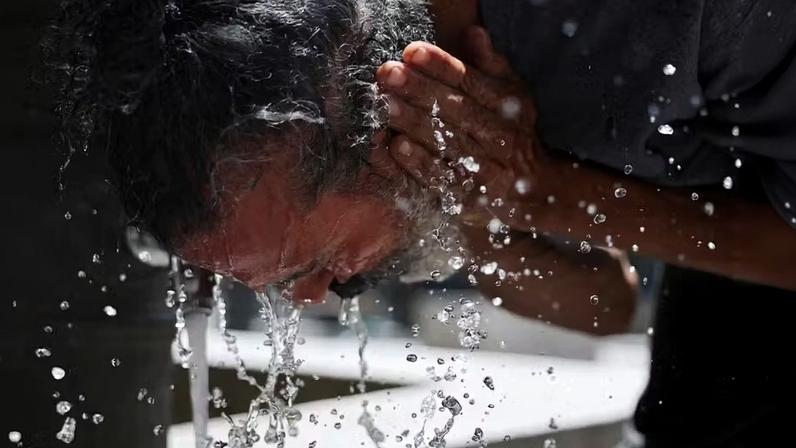 Um homem lava o rosto para se refrescar em um dia quente durante uma onda de calor em Madri, Espanha, em 23 de junho de 2026 — Foto: REUTERS/Mohammed Salem TPX IMAGES OF THE DAY