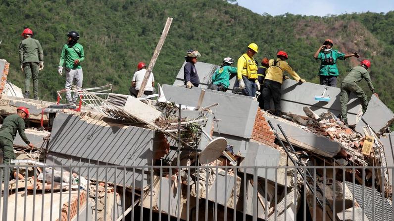 People search for casualties amid the rubble of a collapsed building in the aftermath of earthquakes in Caracas, Venezuela, June 25, 2026. REUTERS/Leonardo Fernandez Viloria