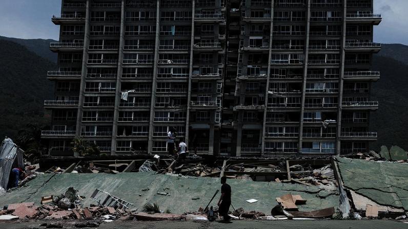 People inspect the rubble of a collapsed building after earthquakes hit the country, in La Guaira, Venezuela, June 25, 2026. REUTERS/Gaby Oraa TPX IMAGES OF THE DAY