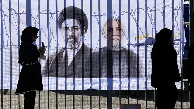Fiéis xiitas se reúnem em frente a uma faixa com fotos do chefe do Hezbollah, Naim Qassem, e do novo Líder Supremo do Irã, Mojtaba Khamenei, para celebrar o Ashura, o dia mais sagrado do calendário muçulmano xiita, nos subúrbios do sul de Beirute, Líbano, em 26 de junho de 2026.