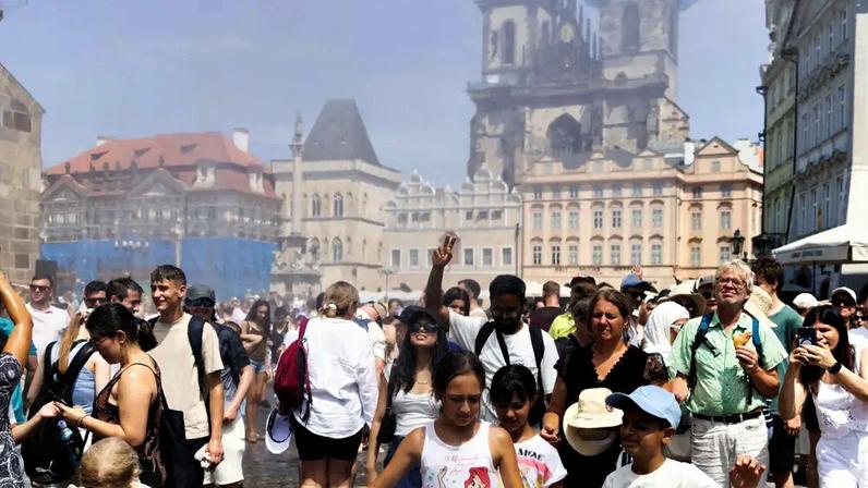 Pessoas são borrifadas com água para se refrescarem durante um dia quente e ensolarado em Praga 28 de junho de 2026 REUTERS/Eva Korinkova