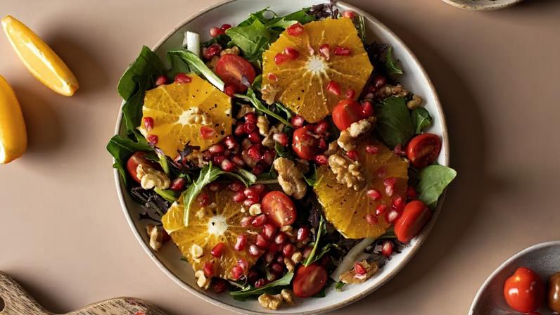 Salada cítrica com romã, nozes e folhas verdes