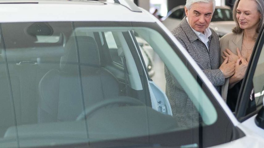 Casal de idosos comprando carro na concessionária