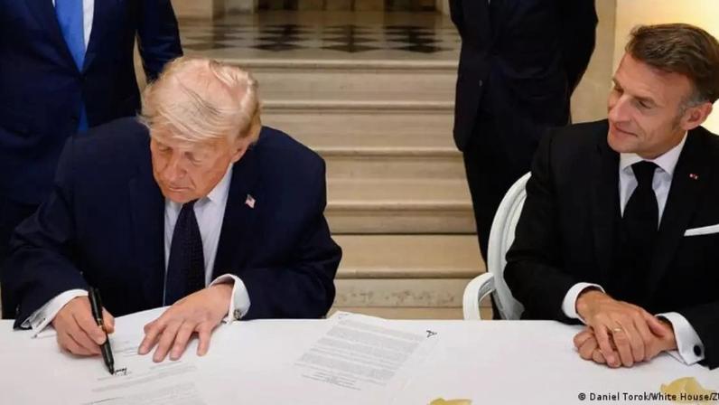 Trump assinando o acordo provisório durante evento em Versalhes, na França