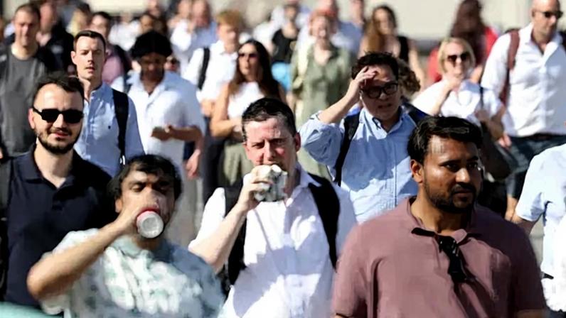 Morning commuters on the London Bridge on Wednesday, where temperatures reached 96 degrees Fahrenheit, the hottest recorded June day in the United Kingdom.