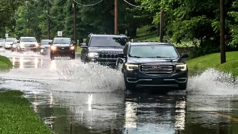 Drivers maneuvered their vehicles through flooded roads after a heavy rainfall in Owensboro, Ky., on Saturday.