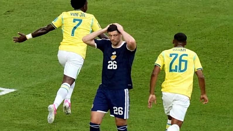 Vinícius Júnior and Rayan celebrate as Scott McKenna holds his head in his hands.