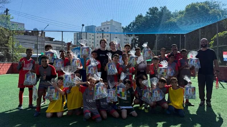 Os estudantes Allan Cohen e Felipe Len (no centro) doam kits para crianças do Ceuzinho Jabaquara em São Paulo