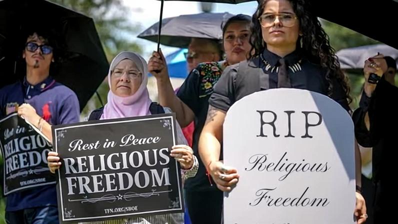 Ruth Nasrullah, left, and Rocio Fierro-Perez, political director for the Texas Freedom Network, participate in an interfaith funeral-themed protest outside the Barbara Jordan building in Austin on 22 June 2026.