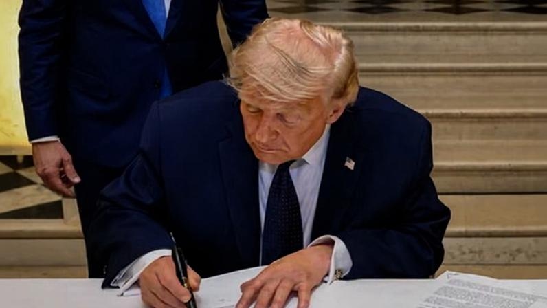 Donald Trump signs the memorandum of understanding at the Palace of Versailles, France.