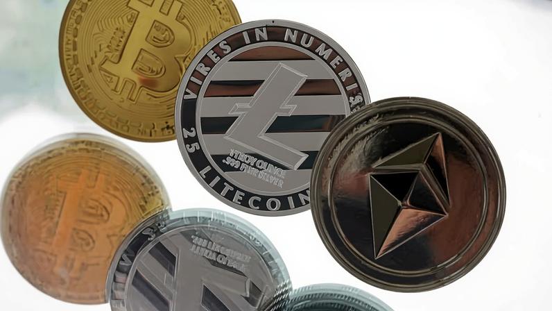 A bitcoin token, left, a litecoin token, centre, and an ethereum token, sit in this arranged photograph in Danbury, U.K., on Tuesday, Oct. 17, 2017. On Wednesday, billionaire Warren Buffett said on CNBC that most digital coins won't hold their value.