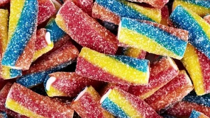 Rainbow sour jelly candy covered in sugar sprinkles