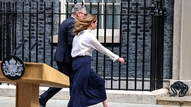 Keir Starmer leaves the No 10 podium with his wife, Victoria, after announcing his resignation, 22 June 2026.