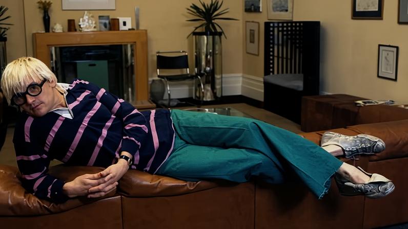 David Hockney: penteado platinado, óculos marcantes, tweed e crocs