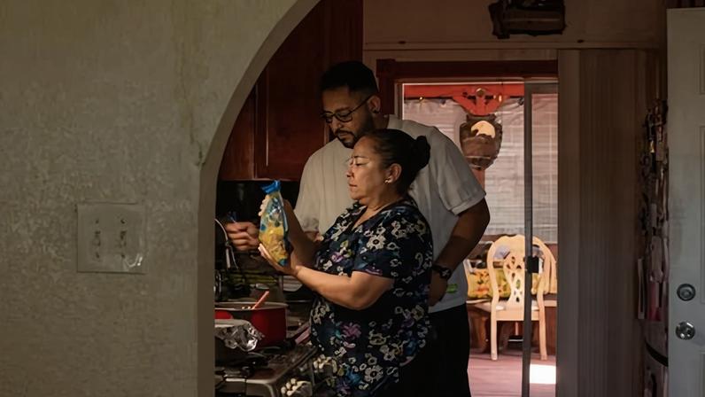 Jhony Silva and his mother, Claudia Carias de Silva, prepare food for the family during Claudia's work break.